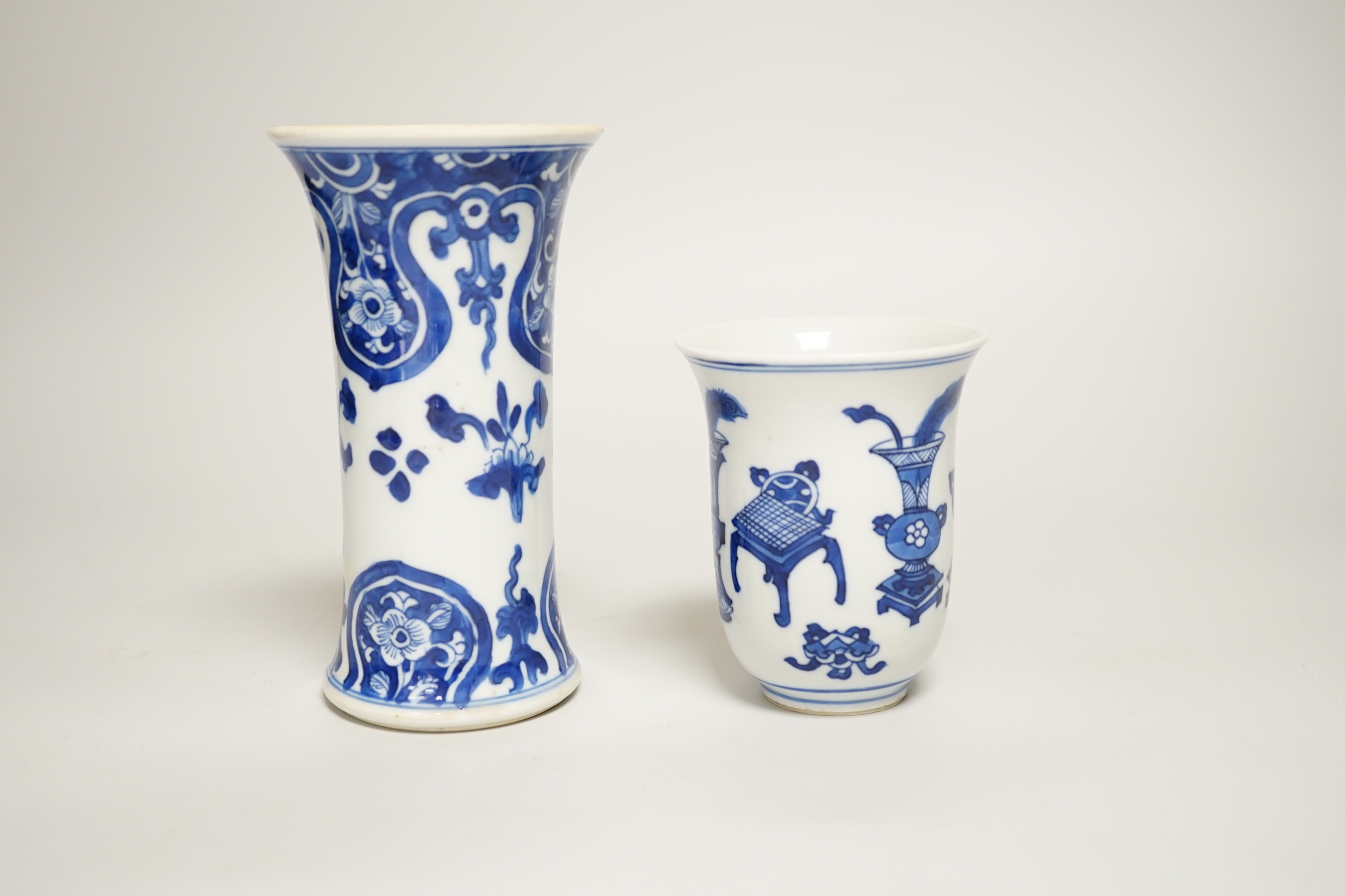A Chinese blue and white small vase and a similar ‘Hundred Antiques’ chocolate cup, both Kangxi period, chocolate cup 9cms high